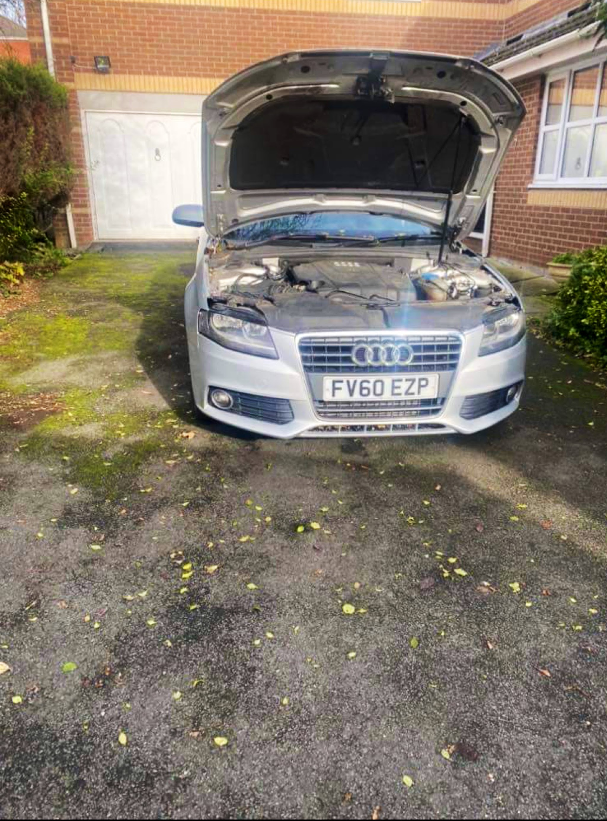 Silver Audi with the bonnet up on a customer's driveway, ready for Eddie to work on