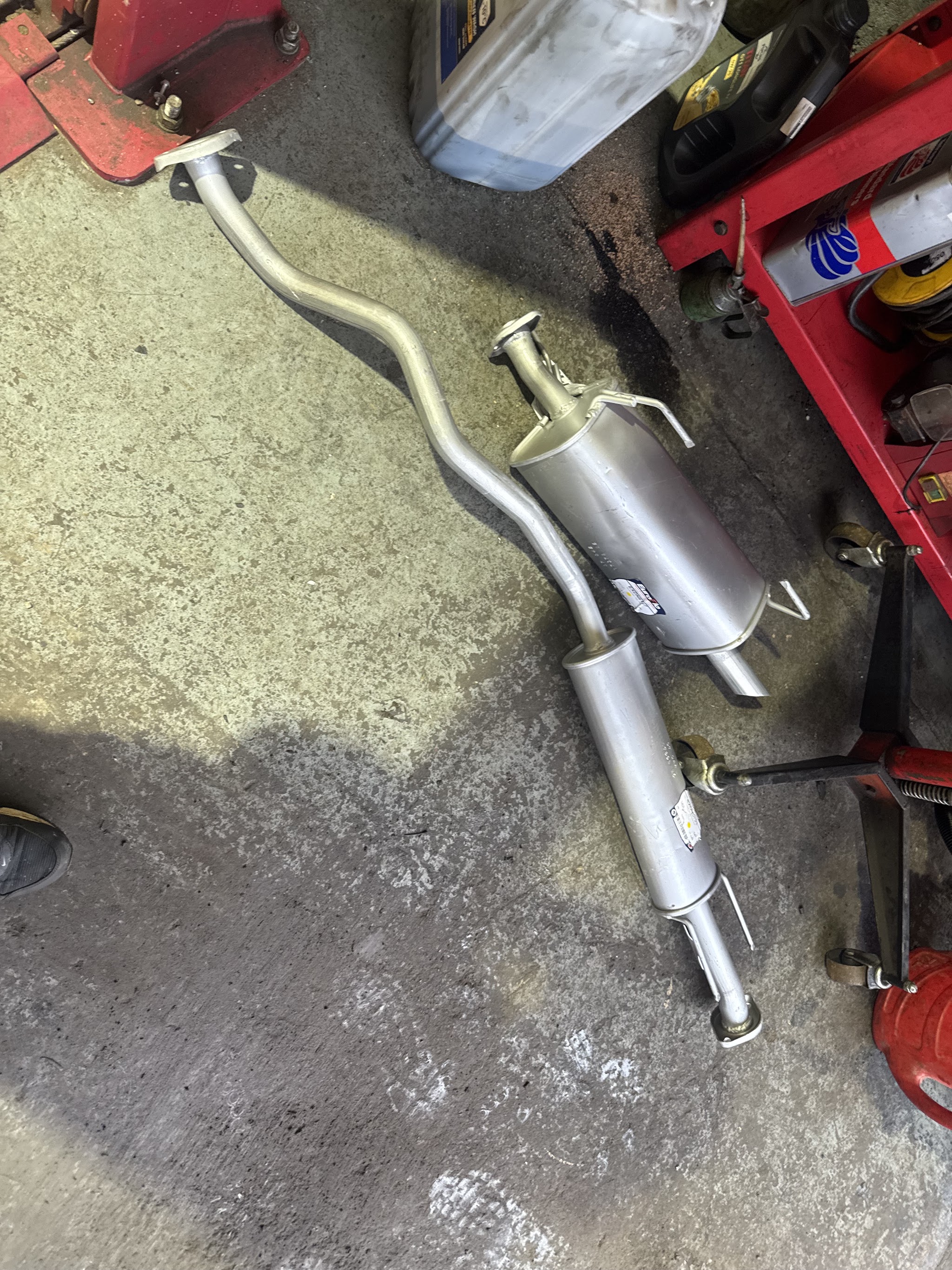 New exhaust system laid out on the workshop floor ready to fit