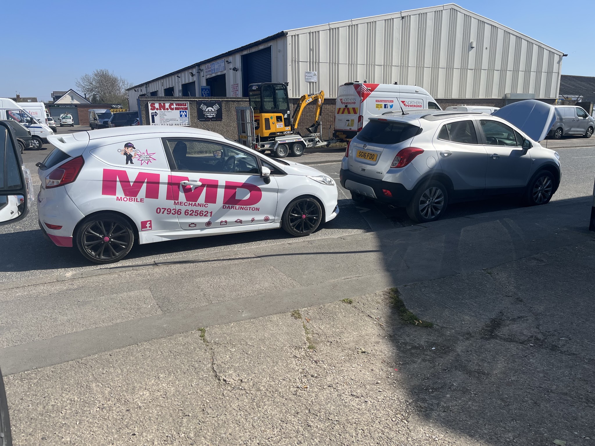 Pink MMD Mobile Mechanic Darlington van parked beside a customer's car with the bonnet up